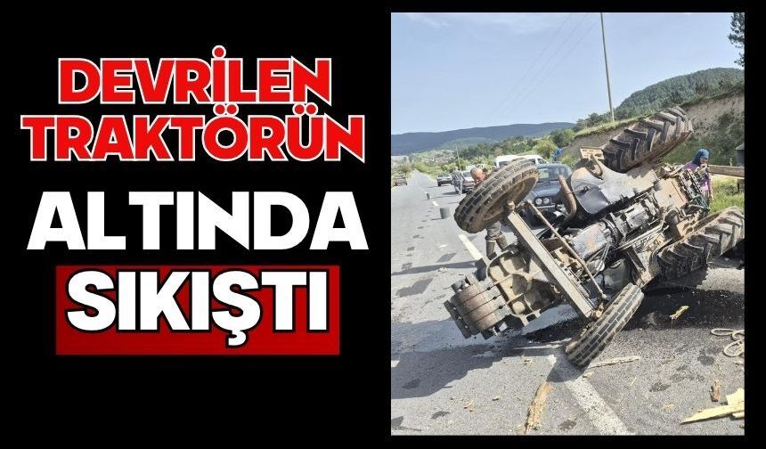 Devrilen traktörün altında sıkıştı