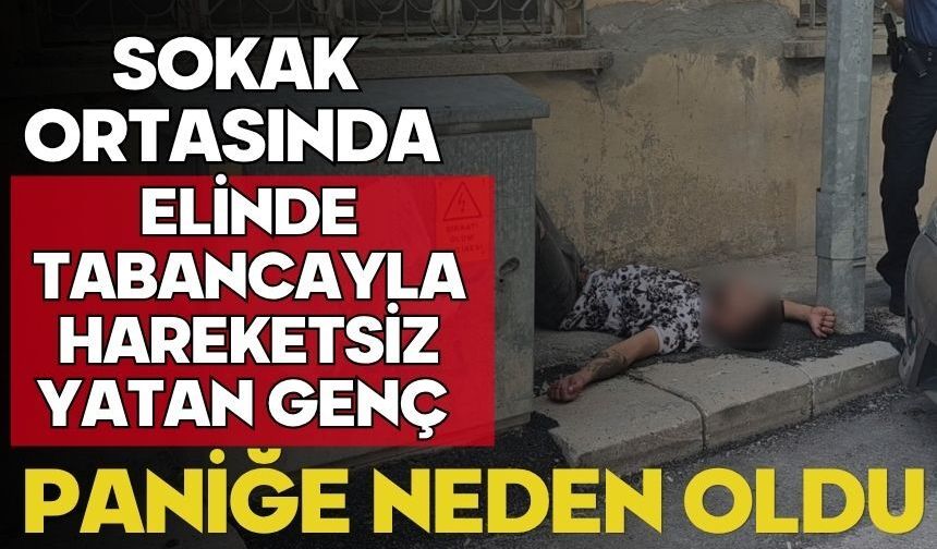 Sokak ortasında elinde tabancayla hareketsiz yatan genç paniğe neden oldu
